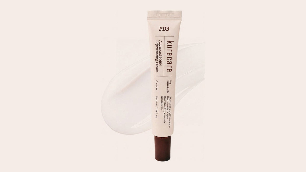 KoreCare PDRN cream tube with a swatch of white gel cream on a soft blush background